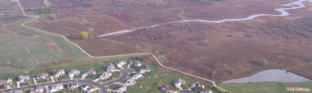 An aerial view of a development next to a wetland.