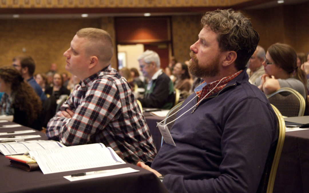 Two people listening at wetland science conference