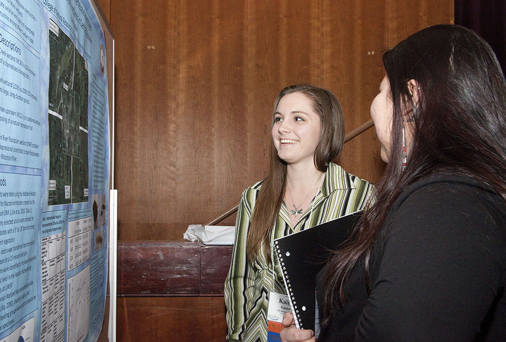 Two women discussing a scientific poster