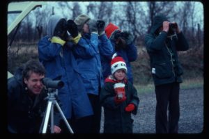 Group looking with binoculars outside
