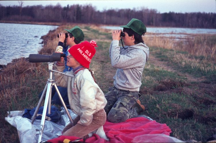 Group of people looking into wetland with binoculars in late winter