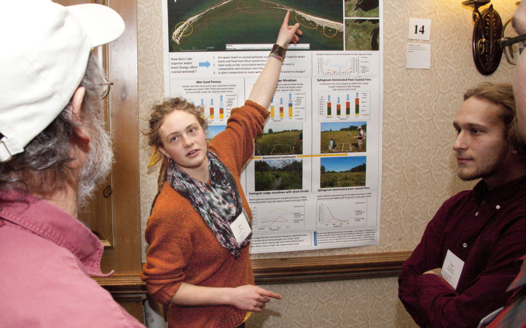 A student poster presenter explains her poster to fellow Wetland Science Conference attendees.