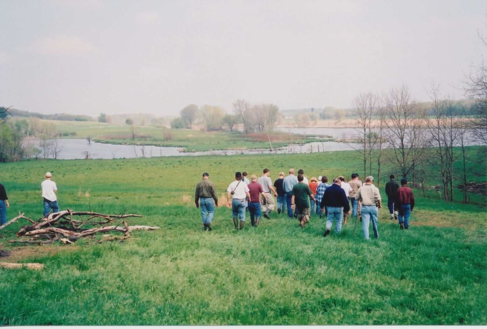 A group of workshop attendees walks towards a wetland.