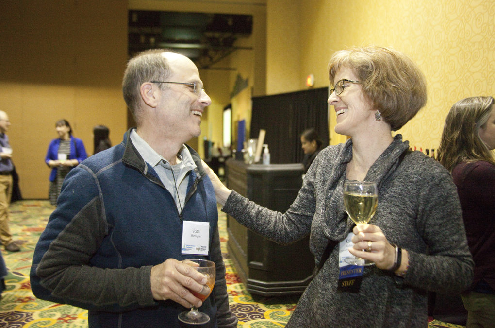 Two people laughing together and enjoying a social hour.