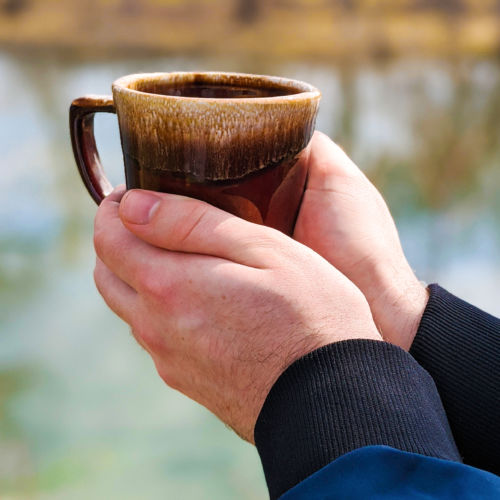 Hands holding a coffee mug.