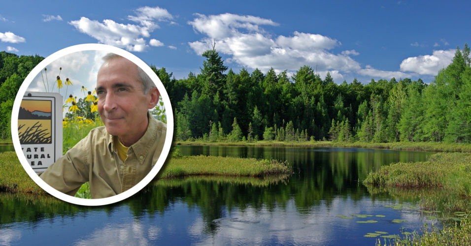 photo of a white male in photo inset in front of a beautiful wetland with open water, trees, and a blue sky with clouds.