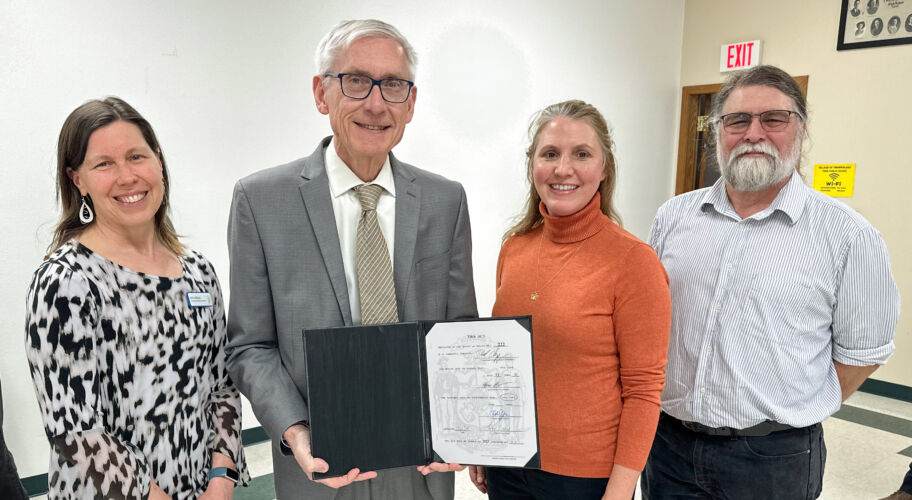 A photo of Governor Evers holding up the signed bill with WWA's Erin O'Brien, Jennifer Western Hauser, and Tracy Hames.